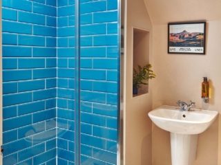 The bathroom with gorgeous bright blue tiles in the Attic Apartment part of Brambles hotel in Inveraray in Scotland