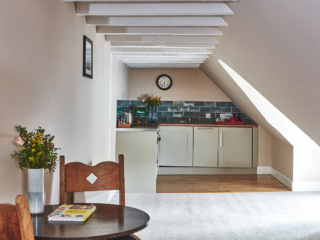 The open plan kitchen and dining in the eaves in the Attic Apartment part of Brambles hotel in Inveraray in Scotland