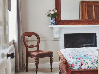 Looking into a double bedroom with antique furniture and a ballon back chair in a Deluxe Room in Brambles hotel in Inveraray in Scotland