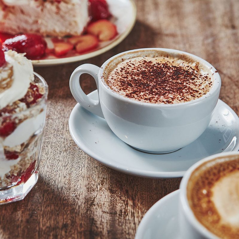 Two desserts and two coffees on a table set for dining in Brambles of Inveraray Hotel restaurant.