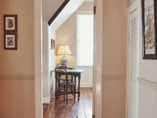 The hallway leading into a room with an antique table and chairs and gorgeous old wooden floor at Lochview Apartment part of Brambles hotel in Inveraray in Scotland