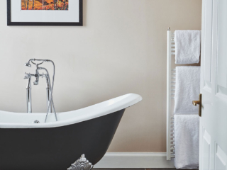 Looking through a door into a bathroom with a stunning roll top bath in a Superior Room in Brambles hotel in Inveraray in Scotland