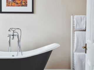 Looking through a door into a bathroom with a stunning roll top bath in a Superior Room in Brambles hotel in Inveraray in Scotland