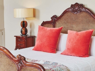An ornate rattan double bed in the Garden Suite in Brambles hotel in Inveraray in Scotland