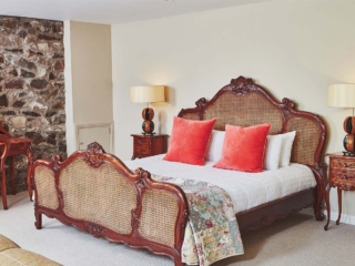 An ornate rattan double bed in the Garden Suite in Brambles hotel in Inveraray in Scotland